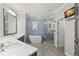 Modern bathroom featuring double vanity, luxurious soaking tub, and glass enclosed shower with blue tiled walls at 1171 Red Maple Ne Cir, St Petersburg, FL 33703