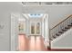 Elegant foyer with decorative glass doors, hardwood floors, staircase and lots of natural light at 1171 Red Maple Ne Cir, St Petersburg, FL 33703