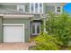 Close up of the entrance to a green home with a three-car garage and paver walkway at 1171 Red Maple Ne Cir, St Petersburg, FL 33703