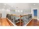 Second floor hallway showcases gleaming wood floors and ornate wrought iron staircase at 1171 Red Maple Ne Cir, St Petersburg, FL 33703