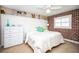 Cozy bedroom with red brick accent wall, a ceiling fan, and white furnishings at 12300 Park Blvd # 222, Seminole, FL 33772