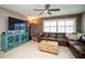 View of a well-decorated living room featuring a ceiling fan, brick accent wall, and sectional sofa at 12300 Park Blvd # 222, Seminole, FL 33772