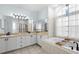 This bathroom features a double sink vanity, large mirror, bathtub and large window for natural light at 12339 Roseland Dr, New Port Richey, FL 34654