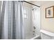 This bathroom features a shower with white tiling, a framed picture, and a gray shower curtain at 12339 Roseland Dr, New Port Richey, FL 34654
