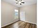 Bright bedroom featuring a ceiling fan, wood-look flooring, and a window with natural light at 12339 Roseland Dr, New Port Richey, FL 34654