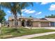 Charming single-story home featuring a manicured lawn, attached two-car garage, and inviting front entrance at 12339 Roseland Dr, New Port Richey, FL 34654