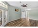 This living room features beautiful wood floors, a ceiling fan, and a doorway to a connected room at 12339 Roseland Dr, New Port Richey, FL 34654