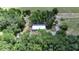 Expansive aerial view of a serene home, surrounded by lush greenery and mature trees at 12434 Cody Dr, Wimauma, FL 33598