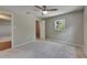 This spacious bedroom features neutral carpet, a ceiling fan, and natural light from the window at 12434 Cody Dr, Wimauma, FL 33598