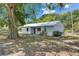 Charming single-story home featuring a metal roof and mature trees in a peaceful, private setting at 12434 Cody Dr, Wimauma, FL 33598