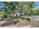 Exterior view of a cozy home surrounded by mature oak trees with Spanish moss in a tranquil setting at 12434 Cody Dr, Wimauma, FL 33598
