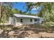 Exterior of home with board and batten siding, shutters, and a metal roof, set on a grassy lot at 12434 Cody Dr, Wimauma, FL 33598