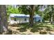 The well-maintained home is surrounded by mature trees and lush landscaping at 12434 Cody Dr, Wimauma, FL 33598