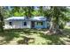 Charming single-story home with a metal roof, quaint shutters, and a well-maintained lawn at 12434 Cody Dr, Wimauma, FL 33598
