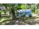A charming home with a metal roof is nestled amidst mature trees, offering a serene retreat at 12434 Cody Dr, Wimauma, FL 33598