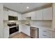 Bright kitchen featuring white cabinets, stainless steel appliances, and modern countertops at 12434 Cody Dr, Wimauma, FL 33598