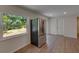 Bright kitchen features stainless steel refrigerator, view to large window, and luxury vinyl plank flooring at 12434 Cody Dr, Wimauma, FL 33598