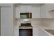 Bright kitchen features stainless steel appliances and white cabinetry for a clean, modern look at 12434 Cody Dr, Wimauma, FL 33598