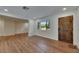 Living room showcasing new floors, a large window, and a beautiful wood front door at 12434 Cody Dr, Wimauma, FL 33598
