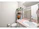 Bright bathroom featuring a sink, toilet, pink counters, and storage shelves at 12648 Castle Hill Dr, Tampa, FL 33624