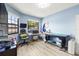 Bright bedroom with three windows, light wood-look floors, and ample space for crafting or other hobbies at 12648 Castle Hill Dr, Tampa, FL 33624