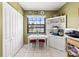 Cozy dining area with a large window, white table and chairs, and a built-in hutch at 12648 Castle Hill Dr, Tampa, FL 33624