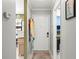 Hallway with tile floors leads to white front door, with view of the kitchen and an adjacent office at 12648 Castle Hill Dr, Tampa, FL 33624