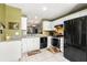 Bright kitchen with white cabinets, black appliances, and a view of the living room beyond at 12648 Castle Hill Dr, Tampa, FL 33624
