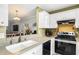 Spacious kitchen showcasing a farm sink, modern faucet, stainless steel appliances and an open layout at 12648 Castle Hill Dr, Tampa, FL 33624