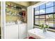 Convenient laundry area next to dining with white washer, dryer, shelving and a bright window view at 12648 Castle Hill Dr, Tampa, FL 33624