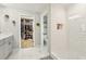 Well-lit bathroom featuring a tile shower with niche, open closet space, and a neutral color scheme at 12830 Bent Twig Dr, Riverview, FL 33579