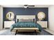 Comfortable bedroom with a dark blue accent wall, decorative mirrors, and ceiling fan at 12949 Shining Blue Nile Ln, Parrish, FL 34219