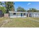 Charming single-story home with a blue front door, solar panels, and freshly painted siding at 1310 43Rd S St, St Petersburg, FL 33711