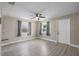 Bright living room featuring modern gray flooring, a ceiling fan, and ample natural light from the windows at 1310 43Rd S St, St Petersburg, FL 33711