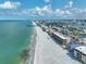 An aerial view shows the coastline with beachfront condos lining the white sand beach with turquoise waters at 13720 Gulf Blvd # 302, Madeira Beach, FL 33708