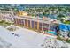 An aerial view showcasing the beachfront condo building with beautiful turquoise waters and a private pool at 13720 Gulf Blvd # 302, Madeira Beach, FL 33708