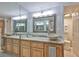 Bathroom featuring double sinks, granite countertops, and wood cabinets at 13720 Gulf Blvd # 302, Madeira Beach, FL 33708