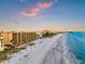 A picturesque beachfront view featuring pristine white sand and turquoise water along multiple oceanfront condos at 13720 Gulf Blvd # 302, Madeira Beach, FL 33708