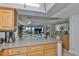 Bright kitchen featuring wood cabinets and views of the living area and balcony at 13720 Gulf Blvd # 302, Madeira Beach, FL 33708