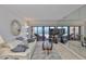 Relax in this inviting living room with ocean views, neutral colors, comfortable seating, and a decorative seashell wreath at 13720 Gulf Blvd # 302, Madeira Beach, FL 33708