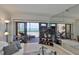 Living room with large sliding glass doors to the screened balcony overlooking the beach at 13720 Gulf Blvd # 302, Madeira Beach, FL 33708