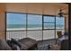 Relax on the screened-in porch with ocean views, comfortable seating, and an overhead ceiling fan at 13720 Gulf Blvd # 302, Madeira Beach, FL 33708