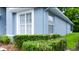Exterior detail of the home showing well-maintained landscaping and a light blue facade at 14116 Whitecap Ave, Hudson, FL 34667