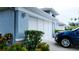 Garage with blue car parked in driveway and some attractive landscaping at 14116 Whitecap Ave, Hudson, FL 34667