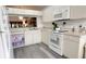 Bright kitchen with white cabinetry, modern appliances, and durable gray wood flooring at 14116 Whitecap Ave, Hudson, FL 34667