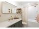 Bright bathroom with white subway tiles, gold fixtures, floating shelves, and a modern vanity at 14902 Foxhound Pl, Tampa, FL 33624