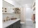 Bright bathroom with white subway tiles, gold fixtures, floating shelves, and a modern vanity at 14902 Foxhound Pl, Tampa, FL 33624