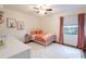 Cozy bedroom with a white metal frame bed, soft rug, and natural light from the window at 14902 Foxhound Pl, Tampa, FL 33624