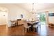 Elegant dining room featuring a modern chandelier, dining table with bench, and sliding glass doors at 14902 Foxhound Pl, Tampa, FL 33624