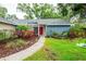 Charming home exterior featuring lush landscaping, walkway, and a welcoming red front door at 14902 Foxhound Pl, Tampa, FL 33624